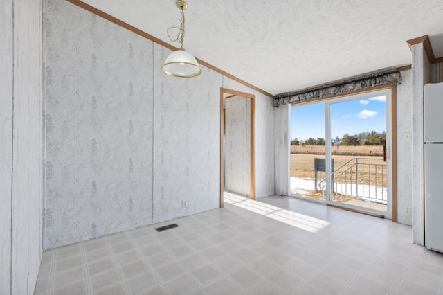 unfurnished room featuring lofted ceiling, visible vents, a textured ceiling, and tile patterned floors