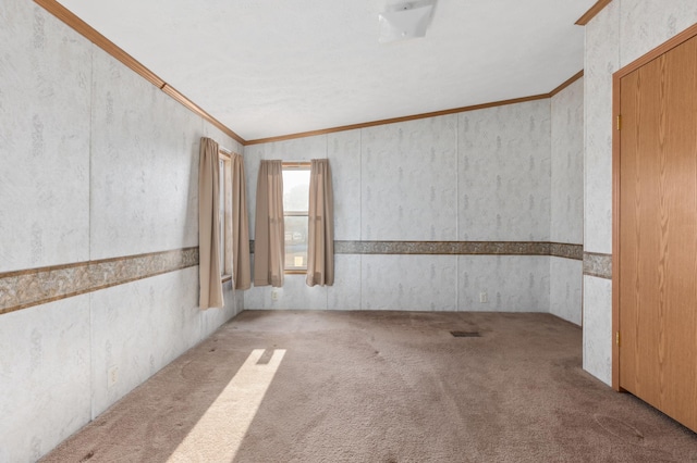 carpeted empty room featuring ornamental molding and visible vents