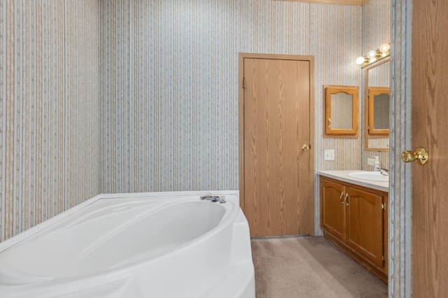 bathroom featuring vanity, a bath, and wallpapered walls