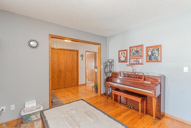 interior space featuring a textured ceiling, baseboards, and wood finished floors