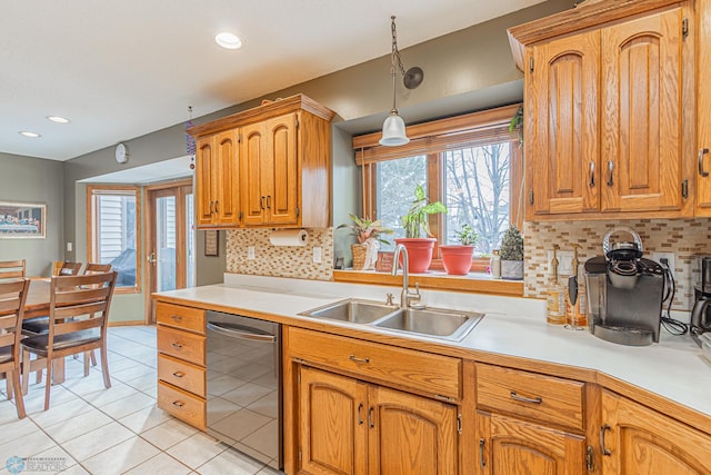 kitchen featuring light tile patterned floors, light countertops, backsplash, a sink, and dishwasher