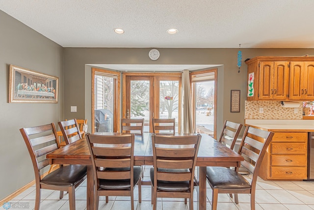 dining area featuring a healthy amount of sunlight, a textured ceiling, and light tile patterned floors