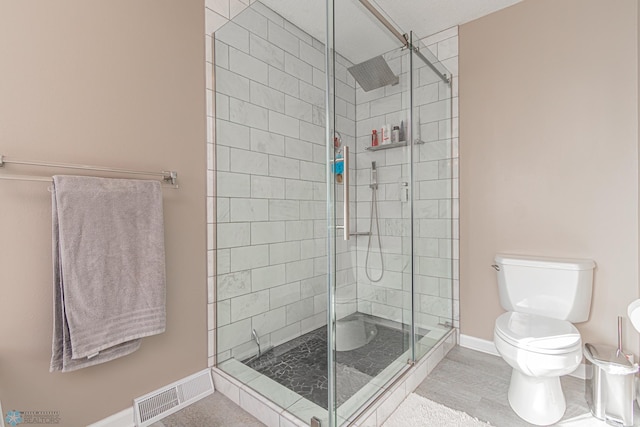 bathroom featuring a stall shower, baseboards, visible vents, and toilet