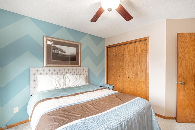 carpeted bedroom featuring a textured ceiling, ceiling fan, baseboards, a closet, and wallpapered walls