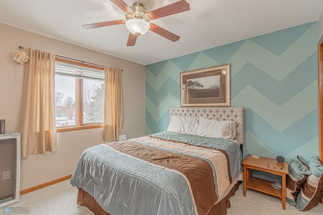 bedroom with ceiling fan, baseboards, a textured ceiling, and carpet flooring