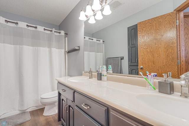 full bathroom with visible vents, a sink, a textured ceiling, and toilet