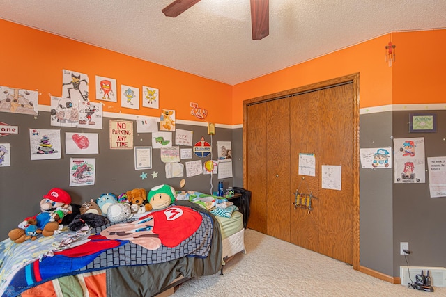 carpeted bedroom featuring a textured ceiling, ceiling fan, and a closet