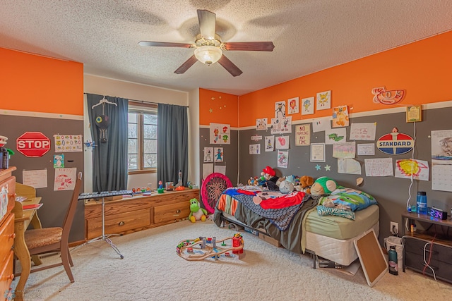 carpeted bedroom with ceiling fan and a textured ceiling