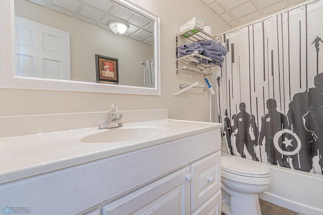 bathroom with a paneled ceiling, vanity, toilet, and shower / tub combo with curtain