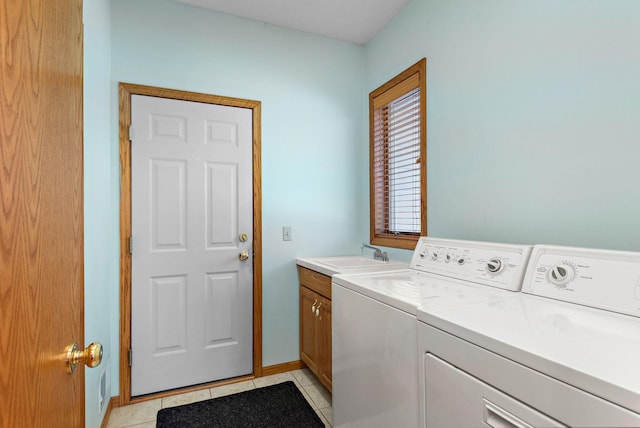 washroom with light tile patterned flooring, cabinet space, a sink, and separate washer and dryer