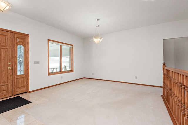 entrance foyer featuring light colored carpet and baseboards