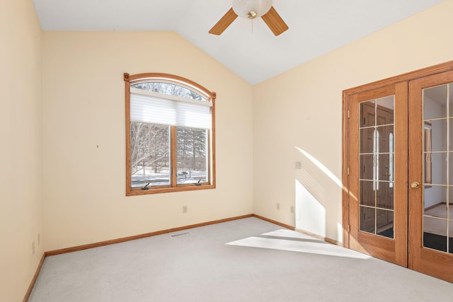 spare room with french doors, lofted ceiling, visible vents, carpet flooring, and baseboards