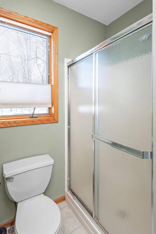 full bathroom with plenty of natural light, a shower stall, and tile patterned floors