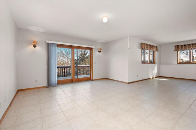 spare room featuring baseboards and a textured ceiling