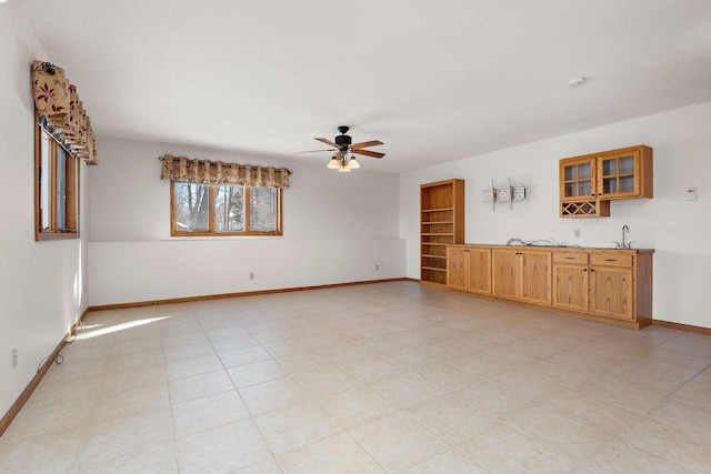 unfurnished room featuring ceiling fan, a textured ceiling, and baseboards