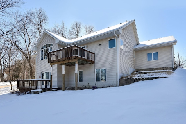 snow covered rear of property featuring a deck