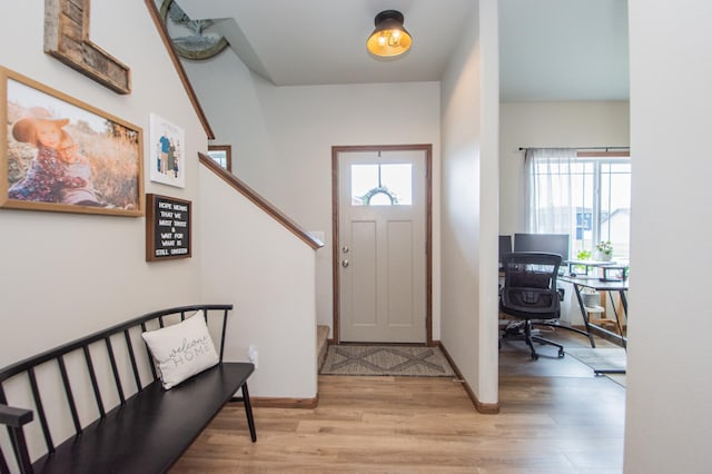 entryway with stairway, light wood-type flooring, and baseboards