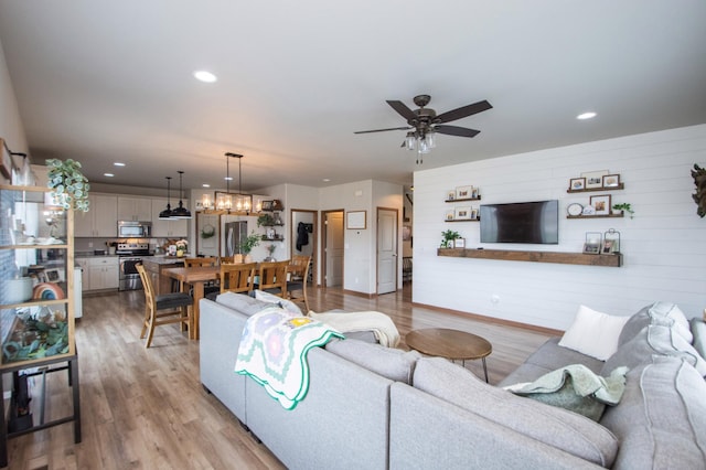living area with recessed lighting, ceiling fan, and wood finished floors