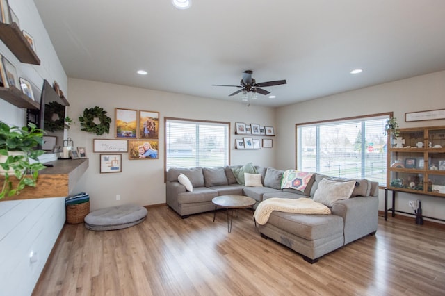 living area featuring light wood-type flooring, a wealth of natural light, and ceiling fan