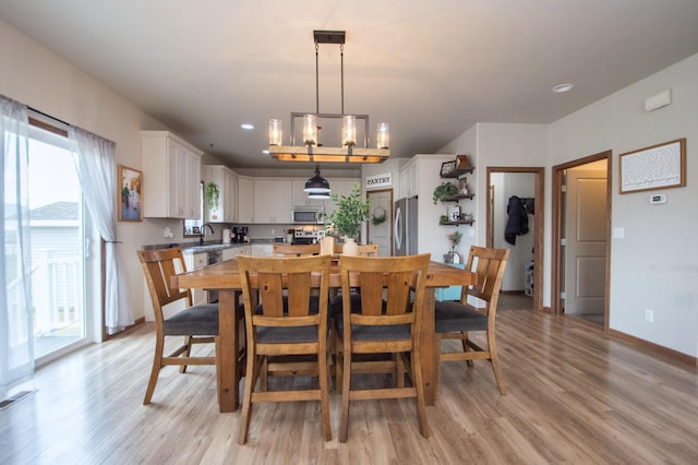 dining room featuring baseboards, light wood-style floors, and plenty of natural light