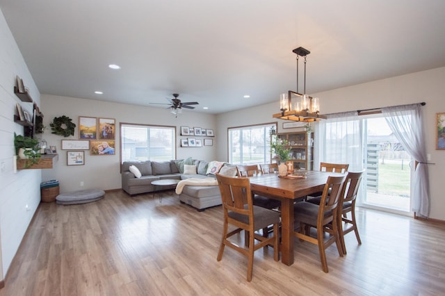 dining space with recessed lighting, ceiling fan with notable chandelier, and light wood-style floors
