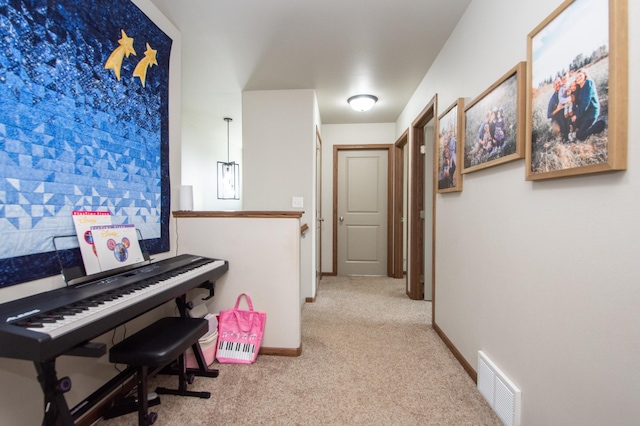 corridor featuring visible vents, carpet, and baseboards