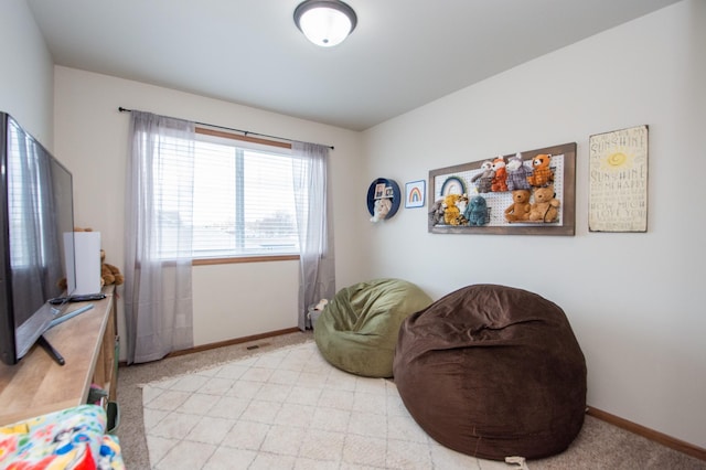 living area with light colored carpet and baseboards