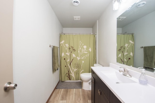 full bathroom with toilet, vanity, and wood finished floors