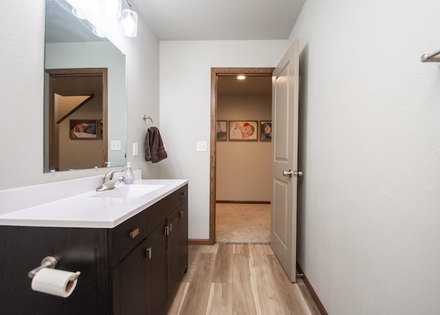 bathroom with wood finished floors and vanity