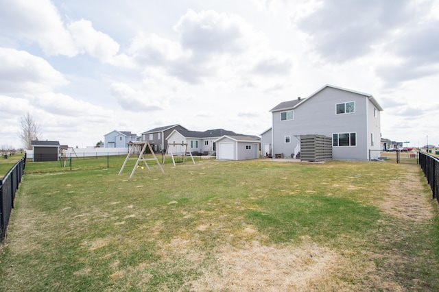 view of yard featuring a fenced backyard, a playground, and an outdoor structure