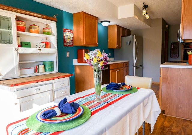 kitchen featuring brown cabinetry, light countertops, and wood finished floors