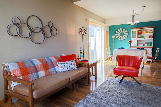 living room with baseboards, wood finished floors, and an inviting chandelier