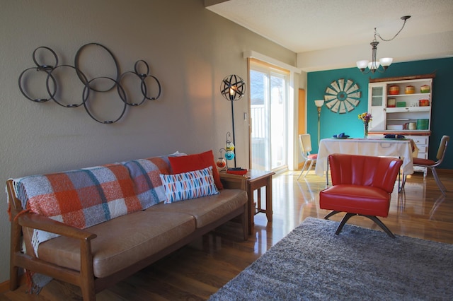 living room featuring a notable chandelier, a textured ceiling, and wood finished floors