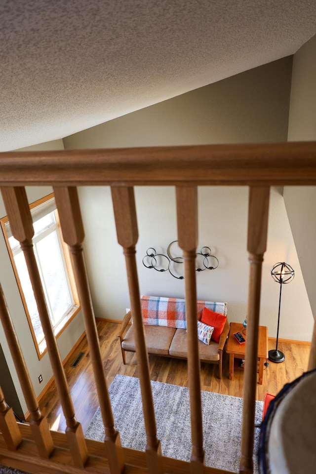 details with a textured ceiling, visible vents, and wood finished floors