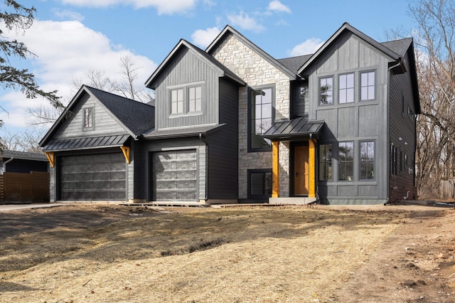 view of front of property with stone siding, board and batten siding, driveway, and a standing seam roof