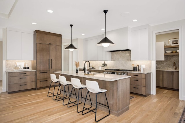 kitchen featuring white cabinetry, modern cabinets, a kitchen bar, and a sink