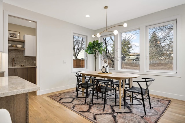 dining area with light wood finished floors, recessed lighting, and baseboards