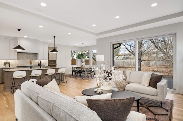 living area featuring light wood finished floors, recessed lighting, and baseboards