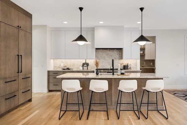 kitchen featuring a kitchen breakfast bar, modern cabinets, and light wood finished floors