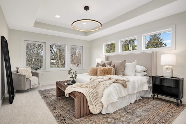 carpeted bedroom featuring a tray ceiling, recessed lighting, and baseboards