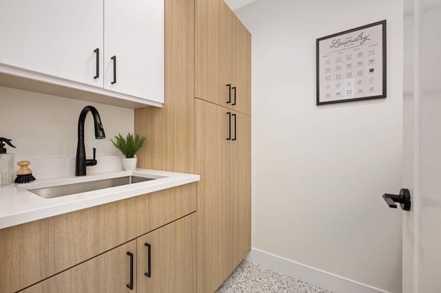 interior space featuring baseboards and a sink