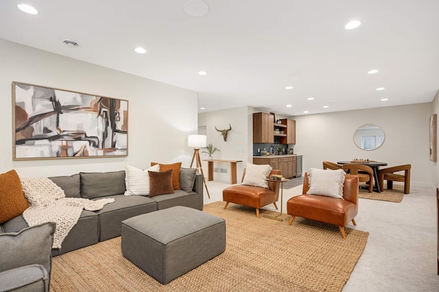 living area featuring recessed lighting, visible vents, and light carpet