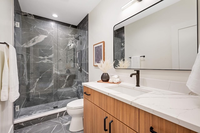 full bath with a marble finish shower, toilet, recessed lighting, marble finish floor, and vanity