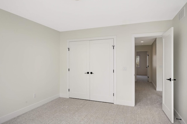 unfurnished bedroom with visible vents, baseboards, and light colored carpet