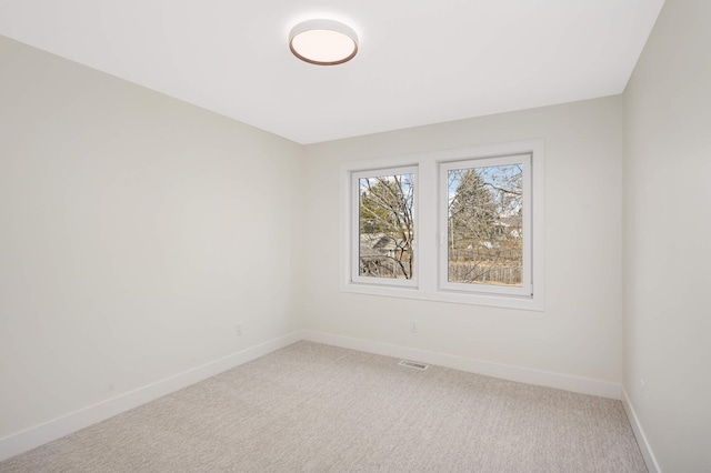 unfurnished room featuring visible vents, baseboards, and light colored carpet