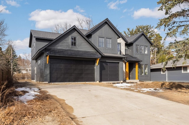 view of front of property with a standing seam roof, concrete driveway, a garage, and metal roof