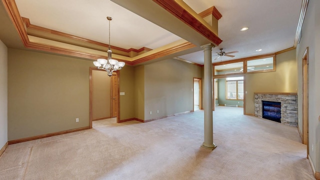 unfurnished living room with ornamental molding, light carpet, a stone fireplace, decorative columns, and a raised ceiling