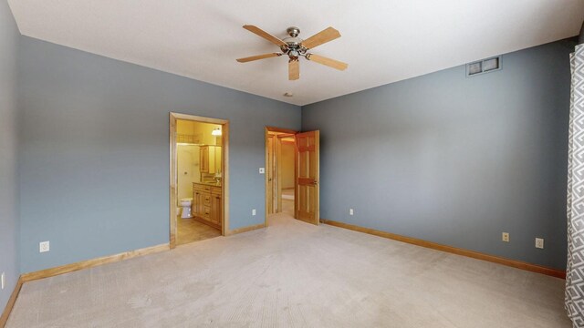 unfurnished bedroom featuring light carpet, ensuite bath, visible vents, and baseboards