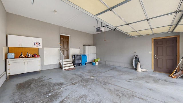 garage with a garage door opener and freestanding refrigerator