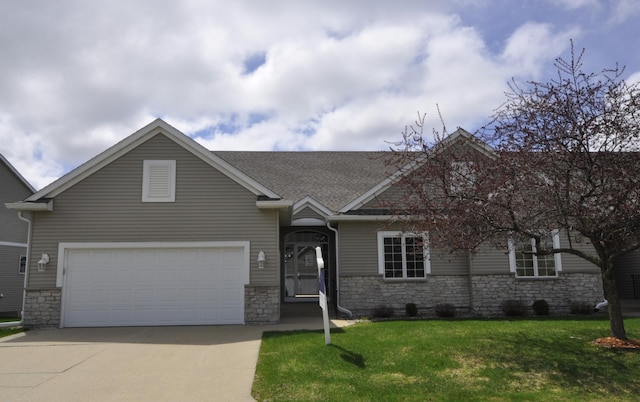 view of front facade with roof with shingles, stone siding, a garage, a front yard, and concrete driveway
